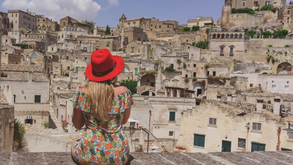 Turista seduta ad osservare i sassi di Matera patrimonio dell'Unesco