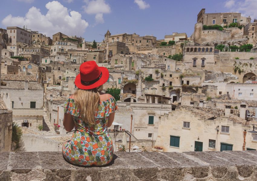 Turista seduta ad osservare i sassi di Matera patrimonio dell'Unesco